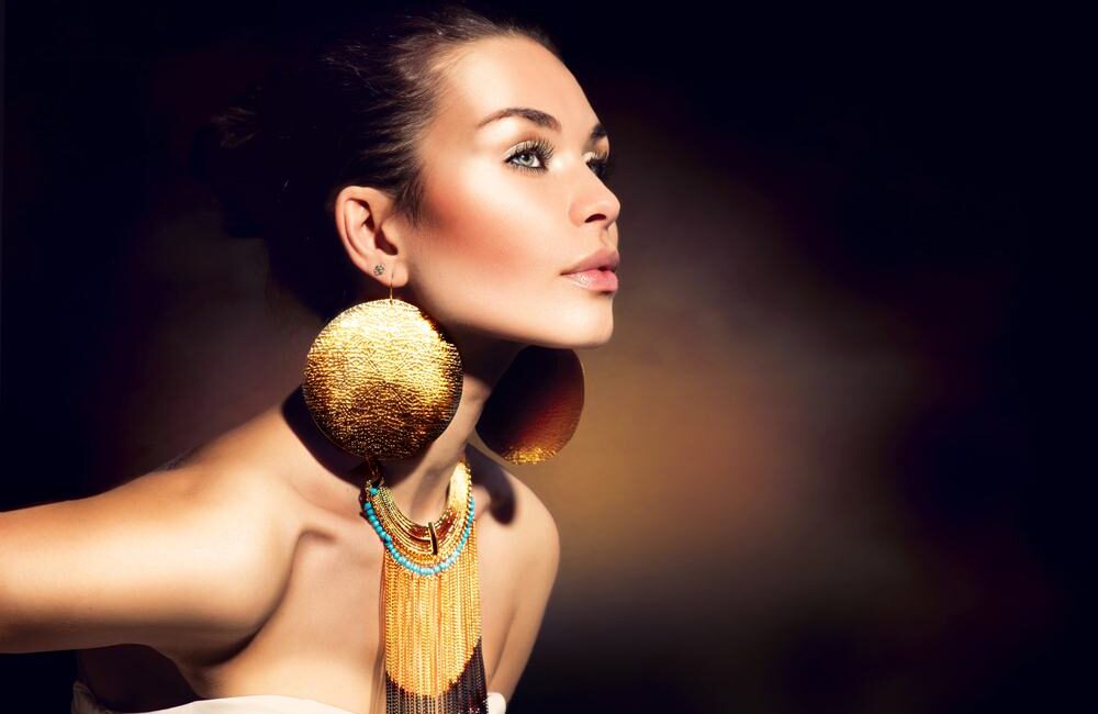 Fashion Woman Portrait. Golden Jewels. Trendy Makeup